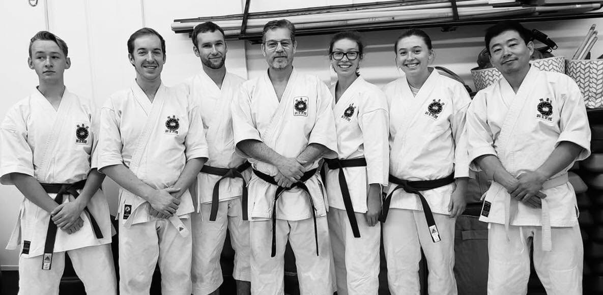 Sensei Walker standing with six students in white gi
